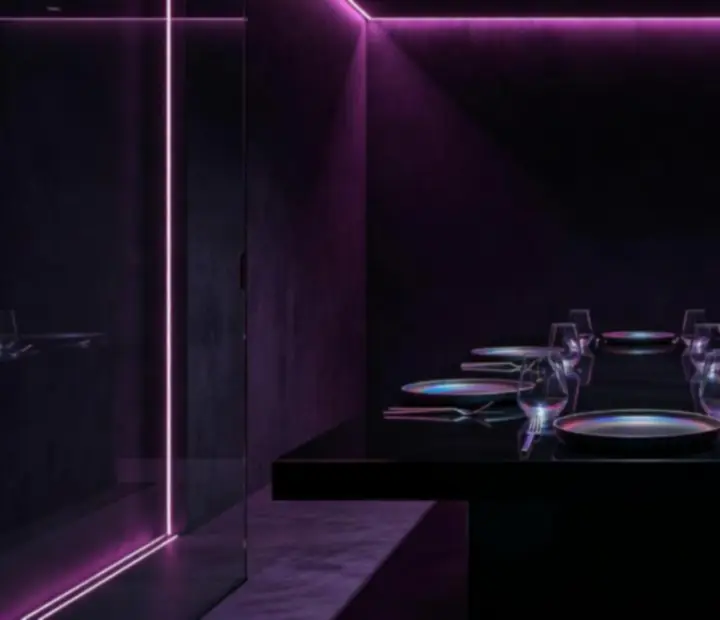 Private dining alcove with futuristic lighting and casino-style table at NAXSOL ENTERPRISES LTD